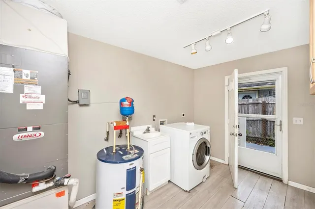 a utility room with dryer washer and a view of living room