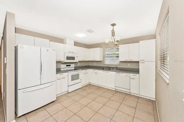 a kitchen with granite countertop white cabinets and white appliances
