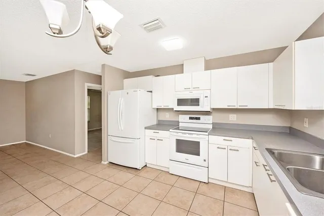 a kitchen with white cabinets and white appliances
