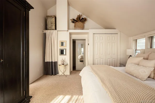 a bedroom with a bed and a refrigerator