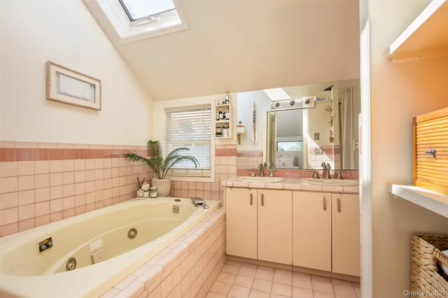 a bathroom with a tub a sink and a large window