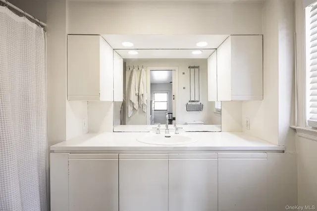 a bathroom with a sink vanity and mirror