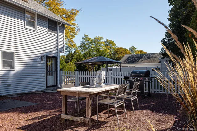 a view of a patio with table and chairs with wooden floor and fence