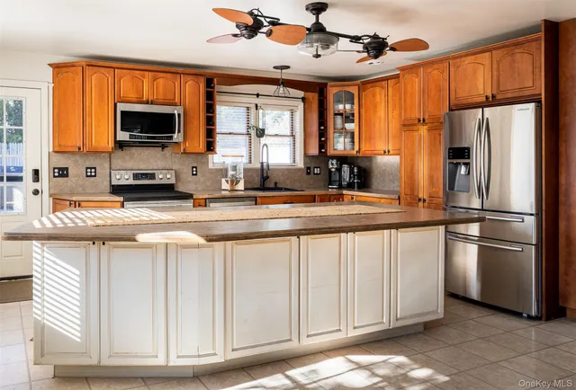 a kitchen with stainless steel appliances granite countertop a refrigerator a stove and a sink with wooden floor