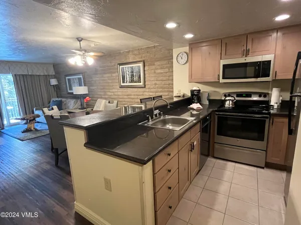 a kitchen with stainless steel appliances granite countertop a sink stove and microwave