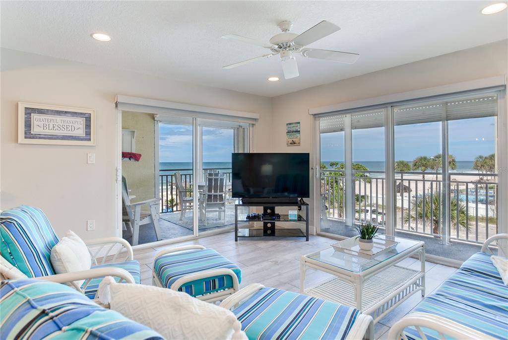 17450 Gulf Boulevard, Unit 206 Redington Shores, FL 33708 - Photo 11 of 52 a living room with furniture a flat screen tv and a large window