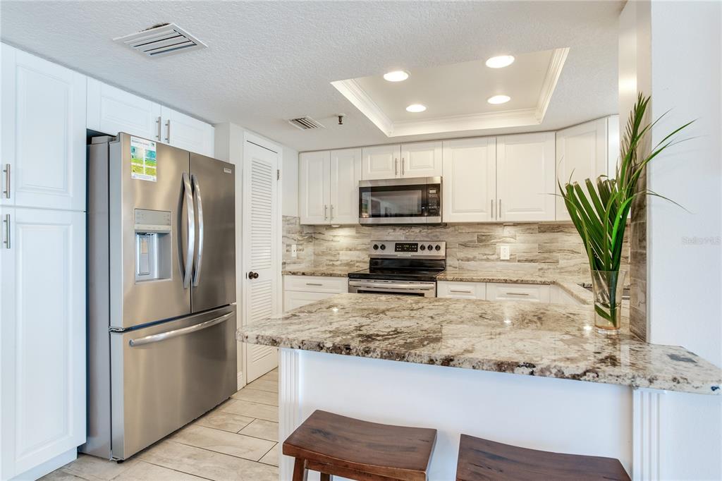 17450 Gulf Boulevard, Unit 206 Redington Shores, FL 33708 - Photo 24 of 52 a kitchen with stainless steel appliances granite countertop a refrigerator a stove and a sink