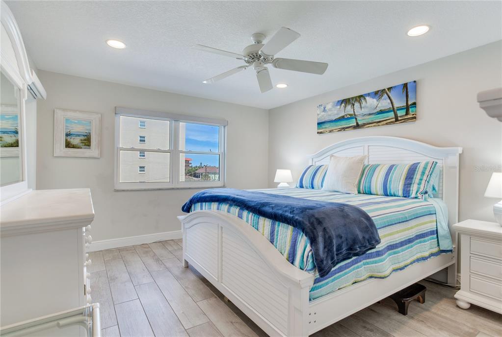 17450 Gulf Boulevard, Unit 206 Redington Shores, FL 33708 - Photo 32 of 52 a bedroom with a large bed and a ceiling fan