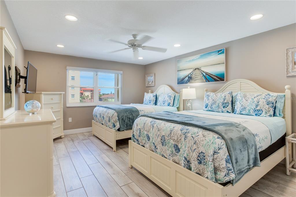 17450 Gulf Boulevard, Unit 206 Redington Shores, FL 33708 - Photo 40 of 52 a bedroom with a large bed and a chandelier