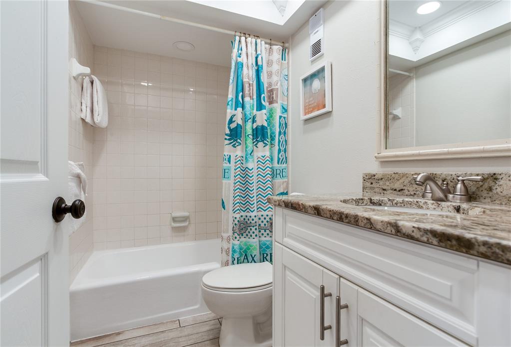 17450 Gulf Boulevard, Unit 206 Redington Shores, FL 33708 - Photo 47 of 52 a bathroom with a granite countertop sink toilet and shower
