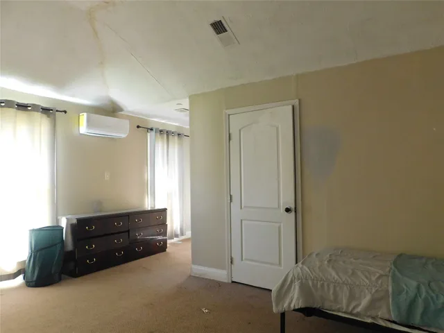 a room with a bed and a dresser