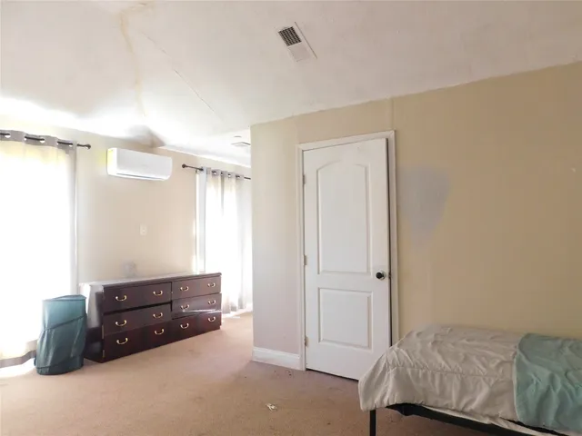 a room with a bed and a dresser