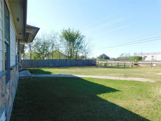 a front view of house with yard and trees in the background