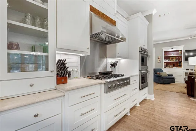 a kitchen with white cabinets and appliances