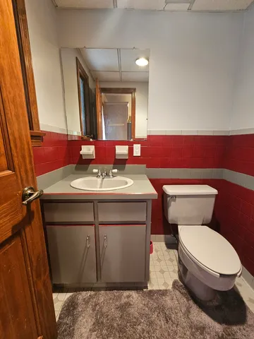 a bathroom with a toilet a sink and a mirror