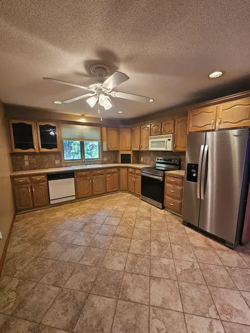 a kitchen with stainless steel appliances granite countertop a refrigerator and a stove top oven