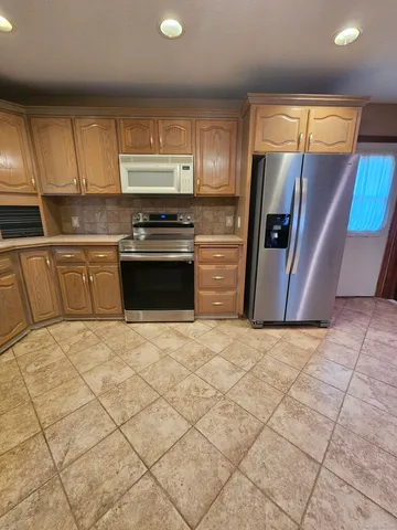 a kitchen with stainless steel appliances granite countertop a refrigerator sink and cabinets