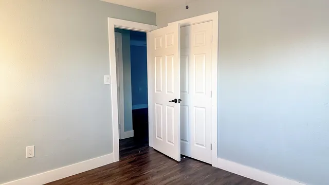 an empty room with wooden floor and closet