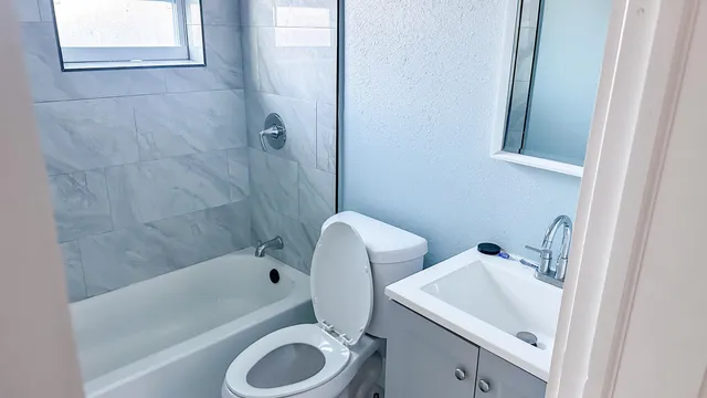 a bathroom with a sink a toilet and bathtub