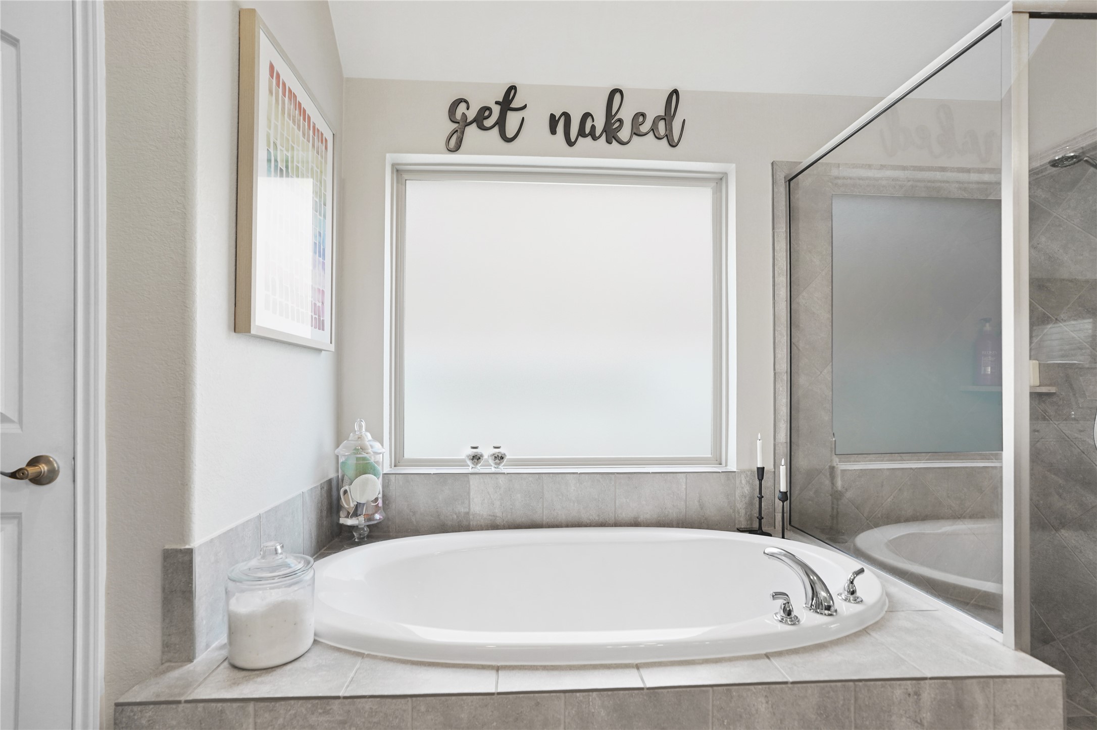 2345 Redwood Ridge Trail Manvel, TX 77578 - Photo 29 of 39 This bathroom features a large, inviting bathtub set against a frosted window, providing natural light and privacy. The space is accented with neutral tiles and decorative touches, creating a cozy and modern feel.