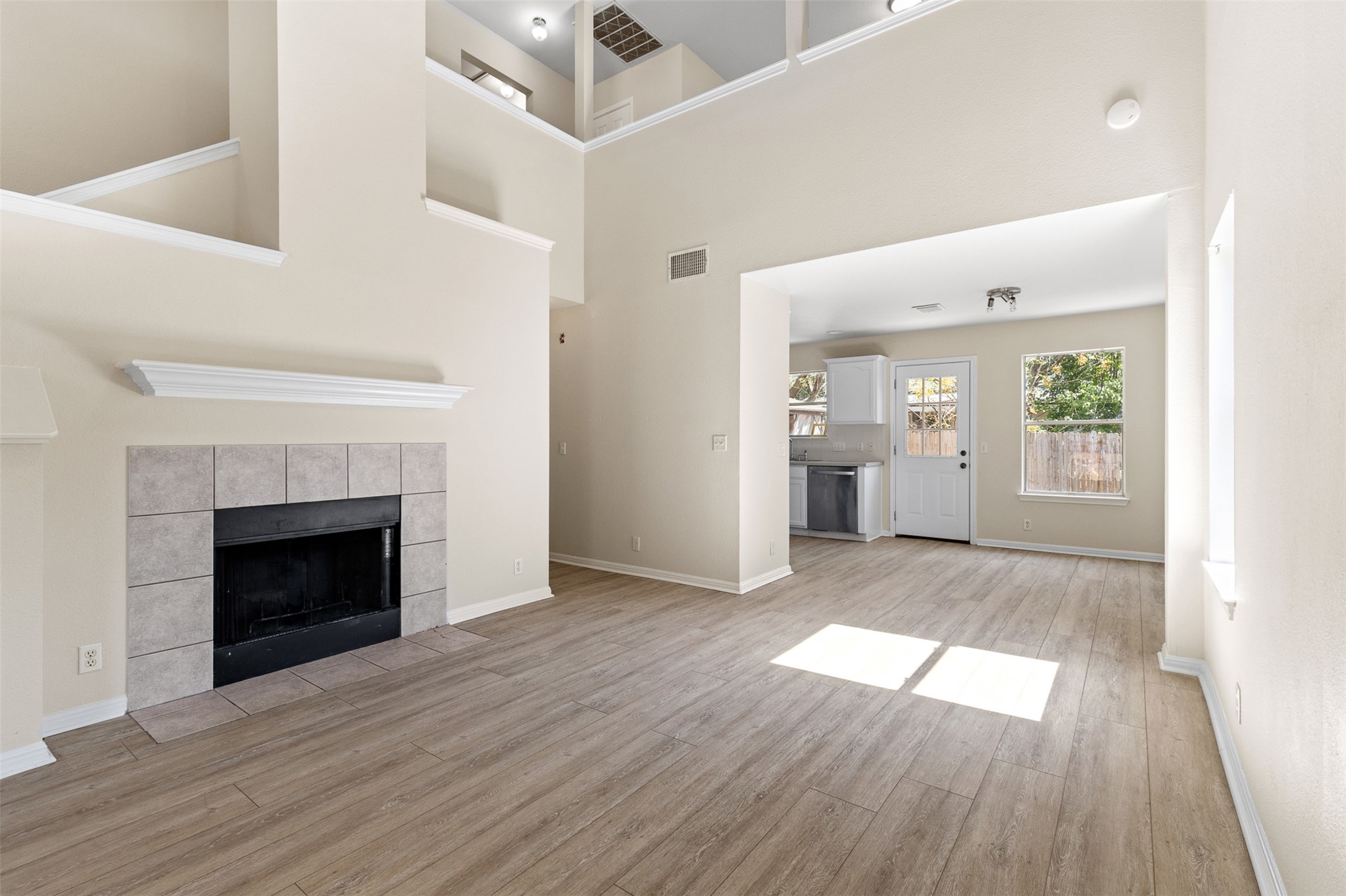 wooden floor fireplace and windows in an empty room