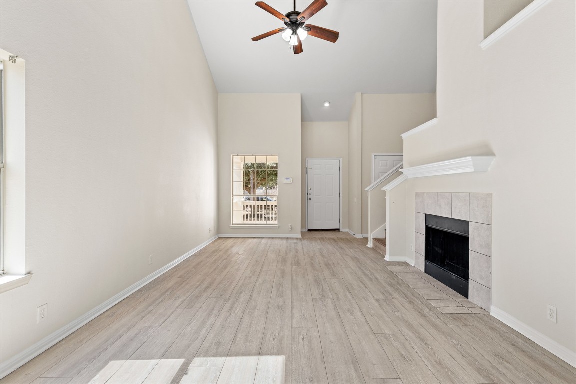 102 Orange Tree Lane Georgetown, TX 78626 - Photo 8 of 31 an empty room with wooden floor fireplace and windows