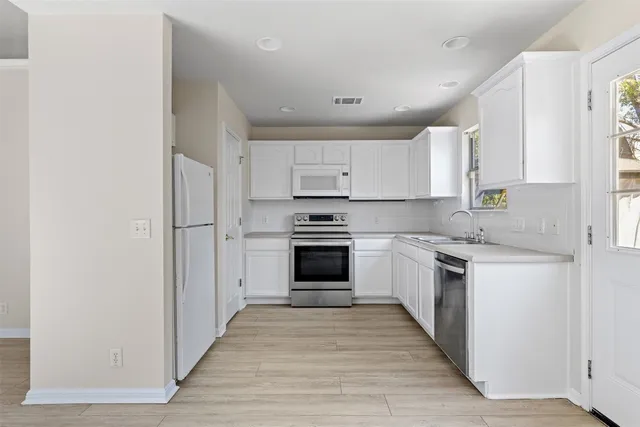 a kitchen with granite countertop a stove top oven and cabinets