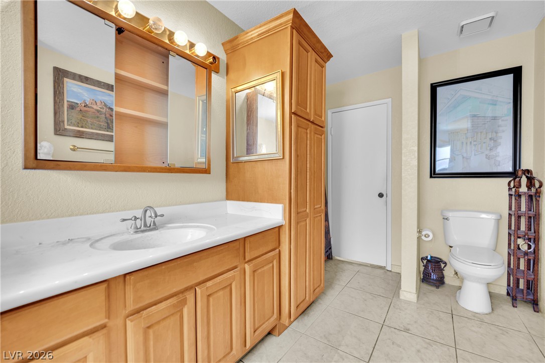 420 North Racetrack Road Henderson, NV 89015 - Photo 33 of 52 A well-appointed bathroom with tile flooring features a spacious vanity and ample storage.