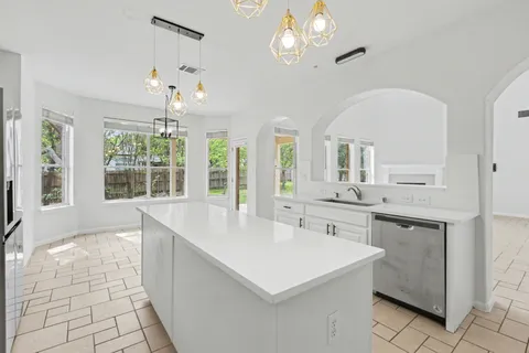 a large white kitchen with a large window