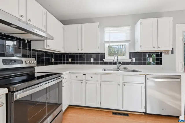 a kitchen with stainless steel appliances granite countertop a sink stove and cabinets