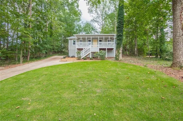 a view of a house with a yard and sitting area