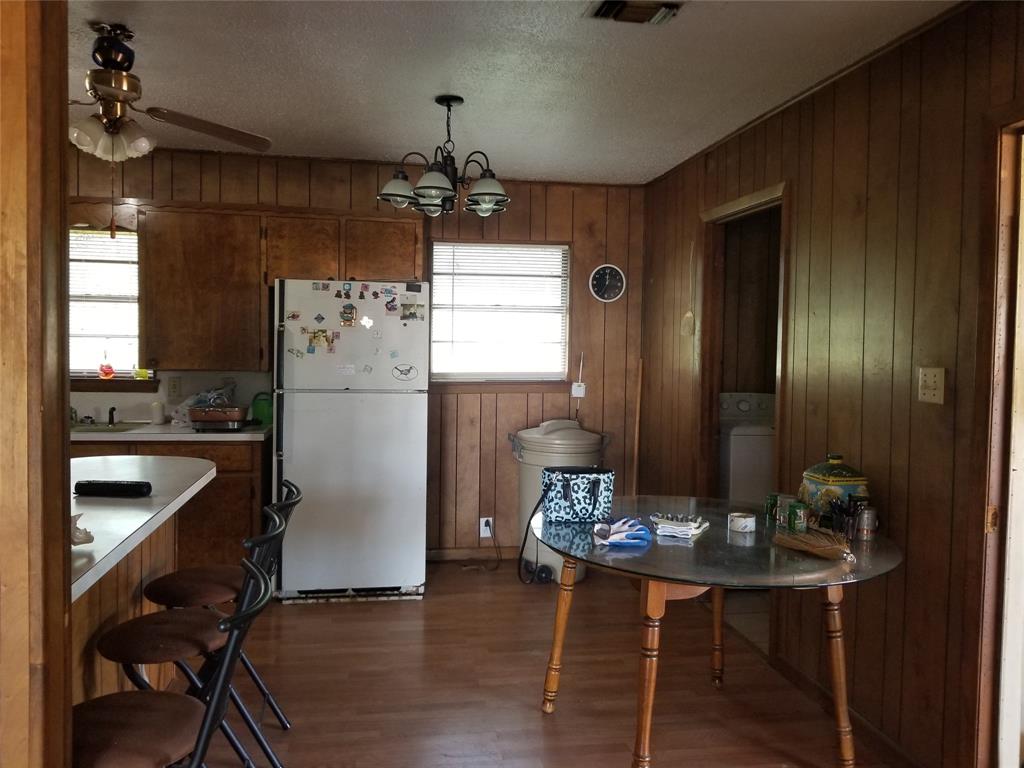 38 County Road 1180 Cooper, TX 75432 - Photo 11 of 25 a kitchen with stainless steel appliances kitchen island granite countertop a refrigerator a stove a microwave oven with a dining table and chairs