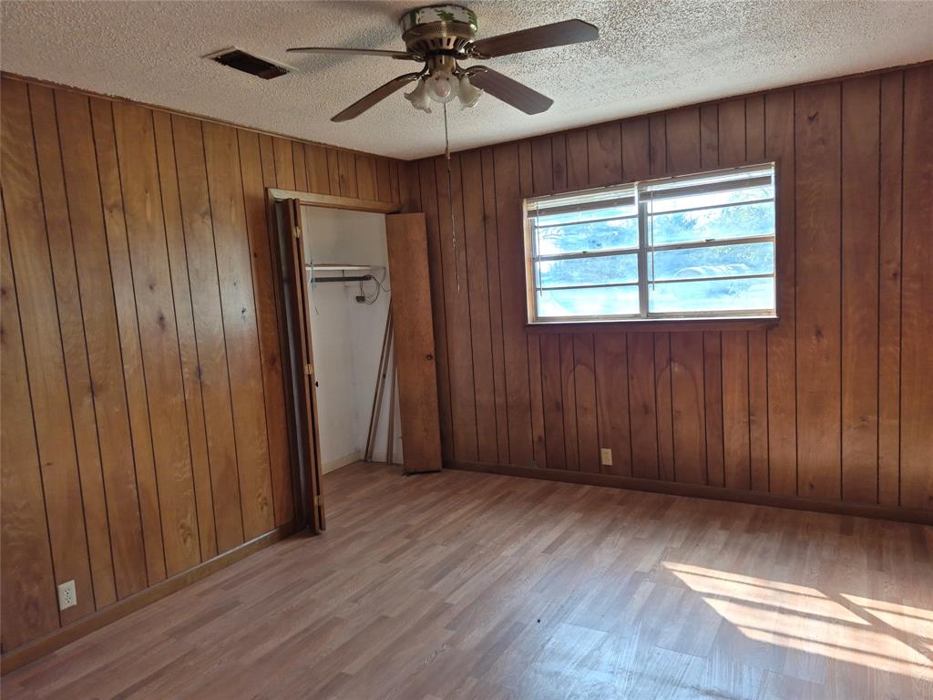 38 County Road 1180 Cooper, TX 75432 - Photo 12 of 25 an empty room with wooden floor chandelier fan and windows