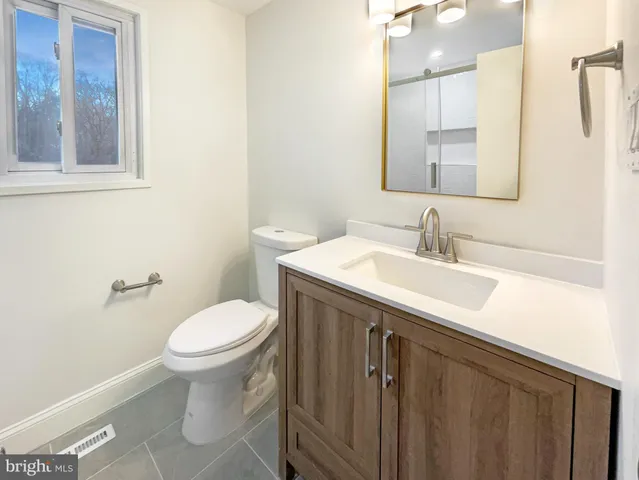 a bathroom with a sink toilet and mirror