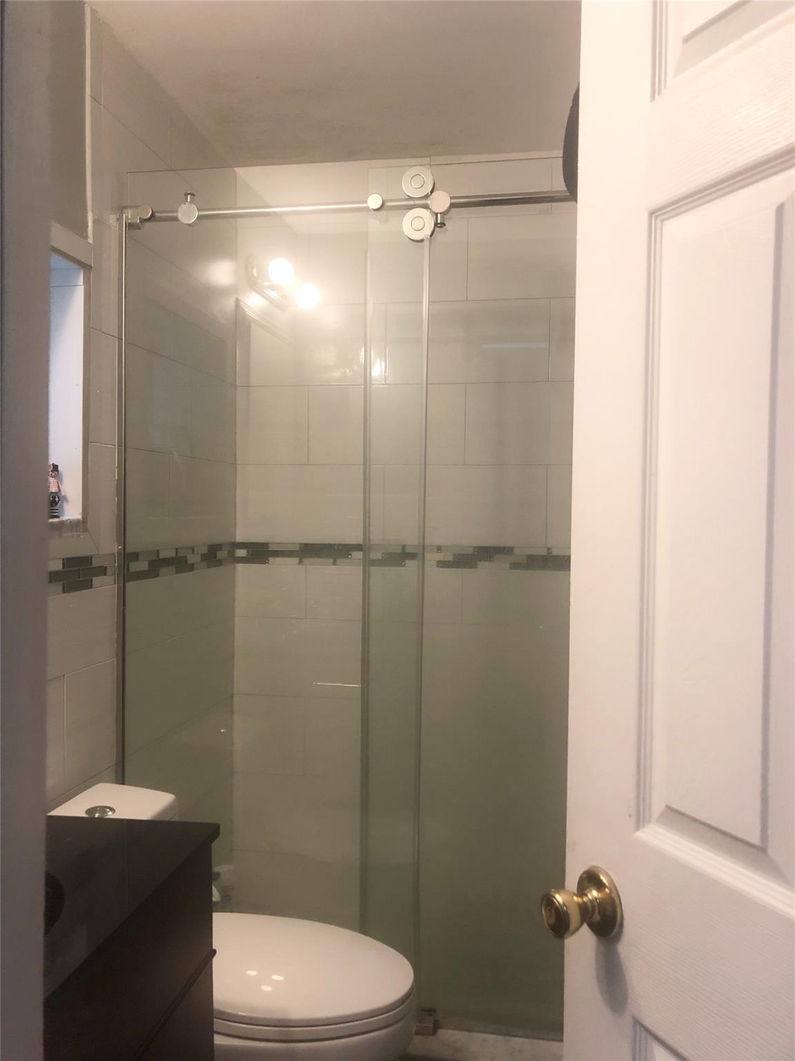 90-28 78th Street Queens, NY 11421 - Photo 9 of 14 Bathroom featuring a stall shower and toilet