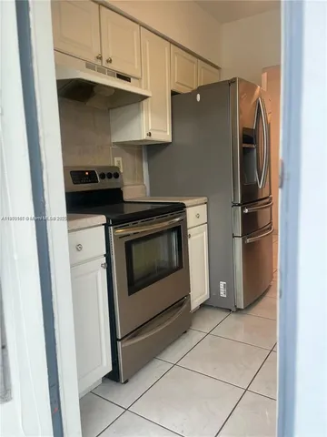 a kitchen with stainless steel appliances granite countertop a refrigerator and a stove