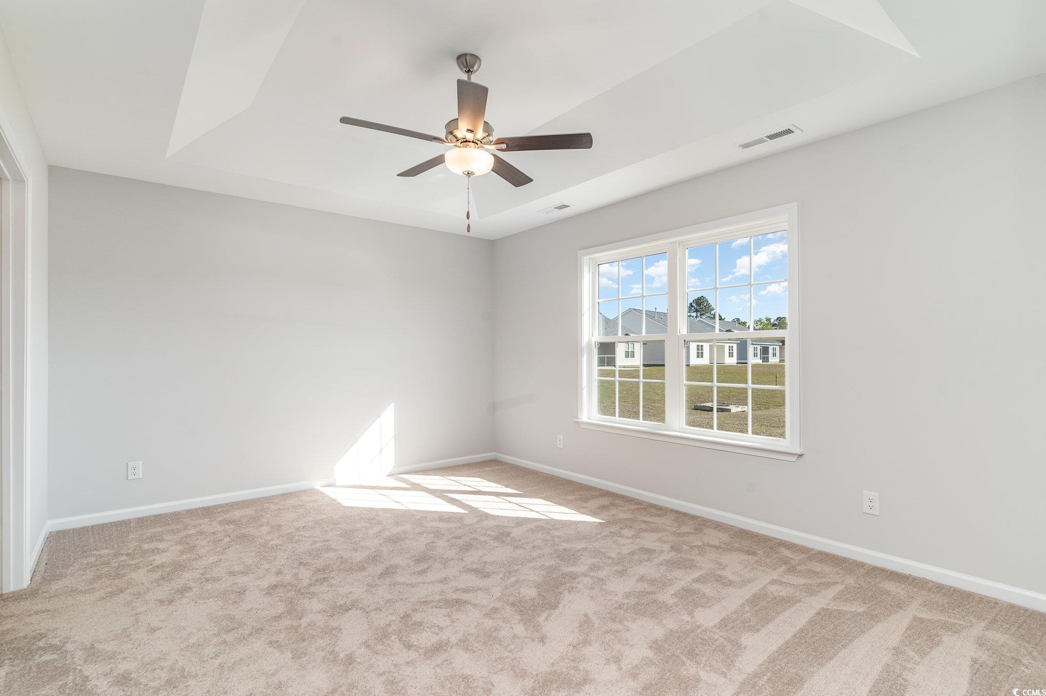 330 Barn Owl Way Conway, SC 29526 - Photo 12 of 23 Empty room featuring light carpet, a ceiling fan, and a tray ceiling