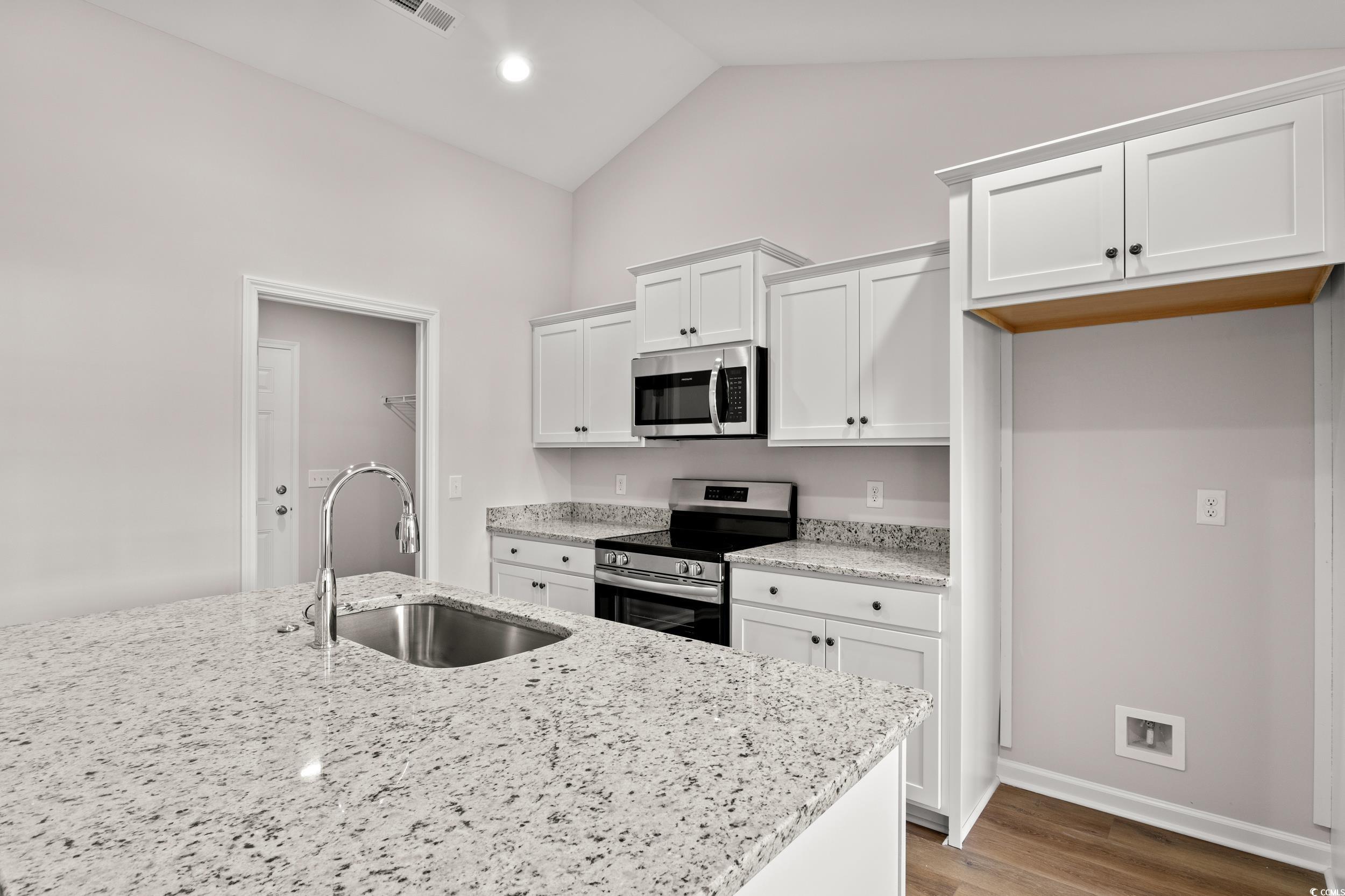 330 Barn Owl Way Conway, SC 29526 - Photo 8 of 23 Kitchen featuring appliances with stainless steel finishes, white cabinetry, light stone counters, light wood-style floors, and high vaulted ceiling