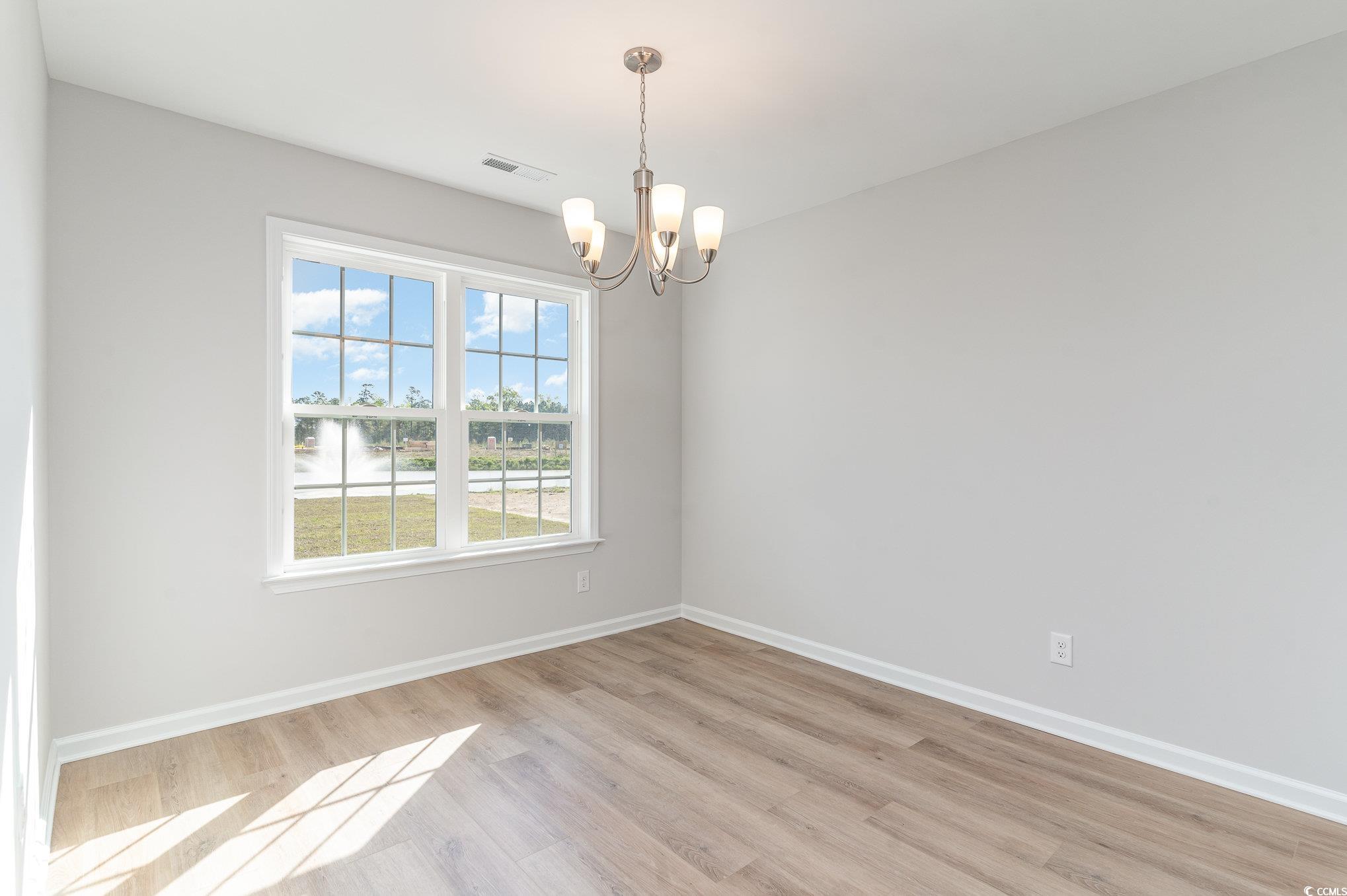 330 Barn Owl Way Conway, SC 29526 - Photo 10 of 23 Unfurnished room with light wood-style flooring and a chandelier
