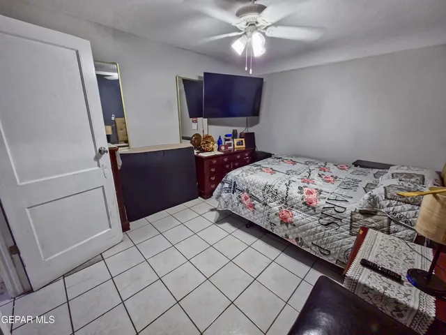 a bedroom with a bed and a flat tv screen on dresser