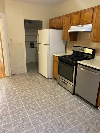 a kitchen with a stove a refrigerator and cabinets