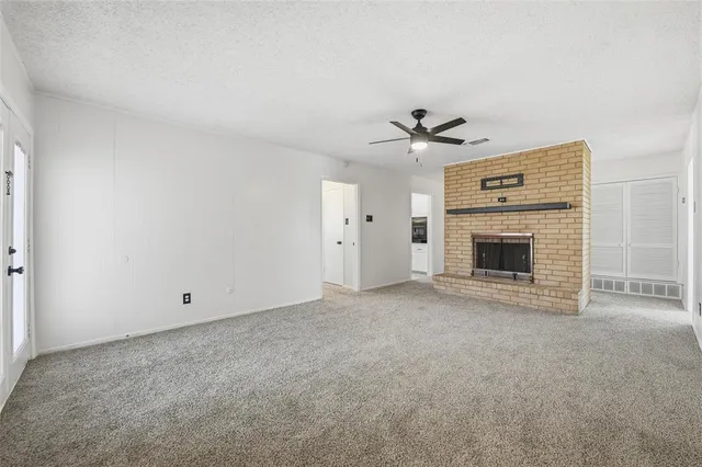 an empty room with fireplace and fan