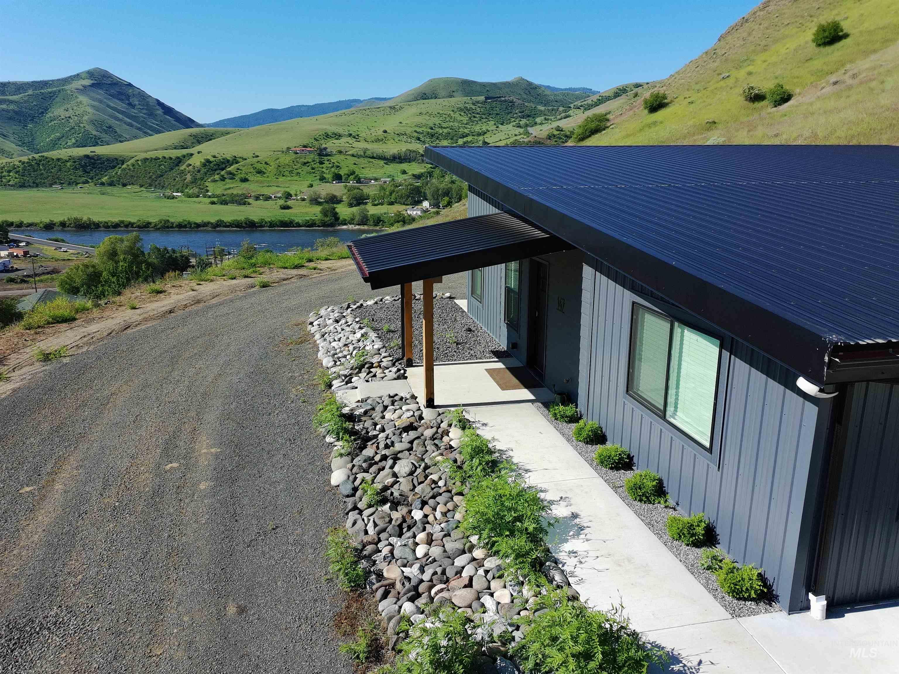 View of home's exterior featuring a metal roof and a water and mountain view