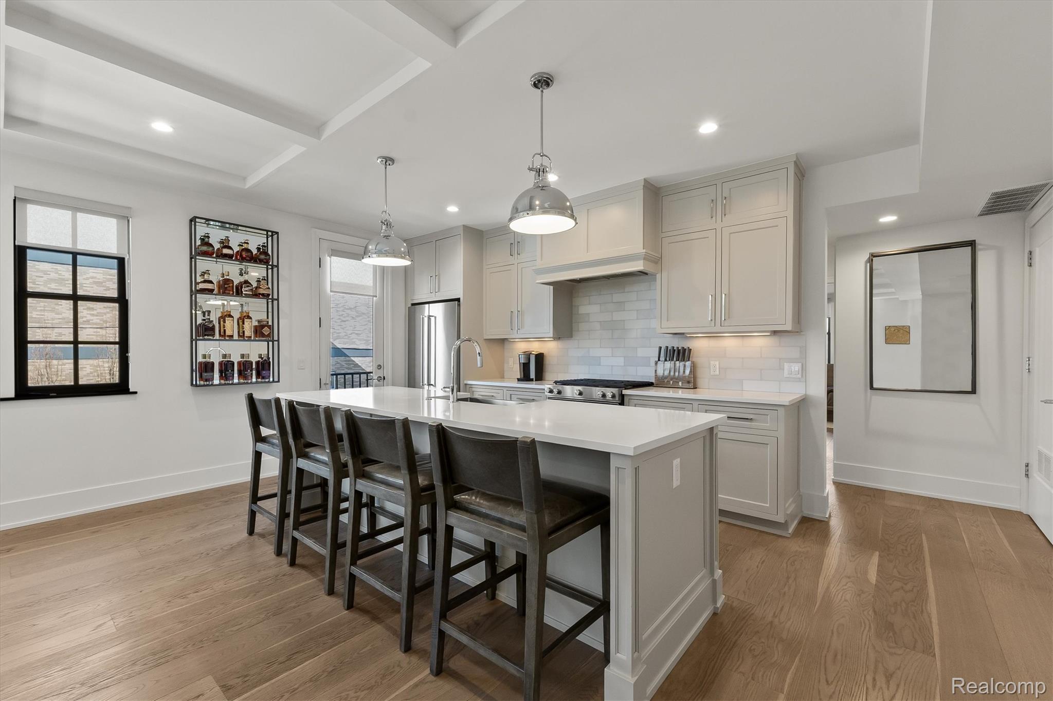936 West Eleven Mile Road Royal Oak, MI 48067 - Photo 7 of 19 Kitchen with a breakfast bar area, a center island with sink, pendant lighting, light wood-style floors, and backsplash