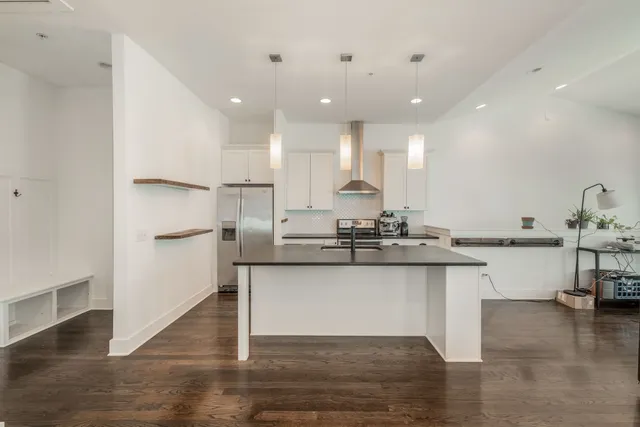 a kitchen with stainless steel appliances granite countertop a sink and a refrigerator