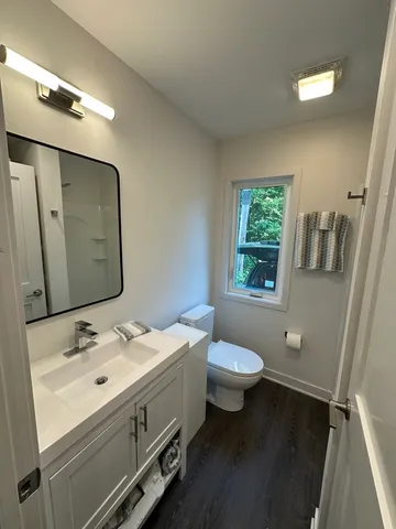 a large kitchen with a sink and dishwasher a stove top oven with wooden floor