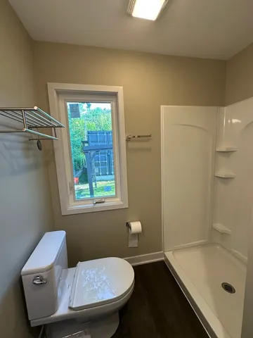 a large white kitchen with a large counter top space a sink a window and stainless steel appliances