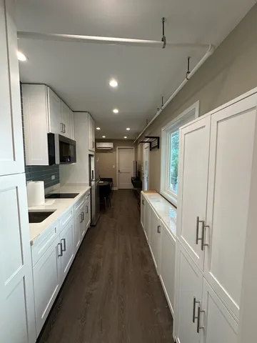 a large kitchen with stainless steel appliances granite countertop a sink and a stove top oven