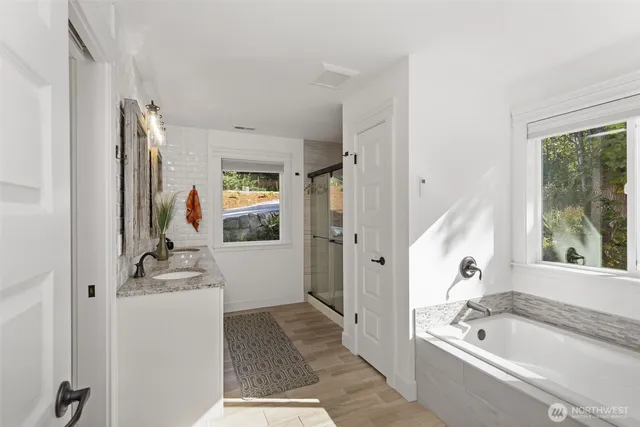 a bathroom with a tub sink and mirror