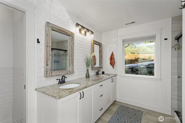 a bathroom with 2 sink and a window